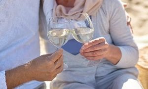 Couple toasting with wine at the beach